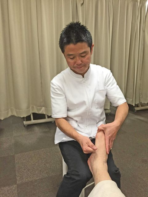 足首まわりを確かめながら行う足つぼ施術